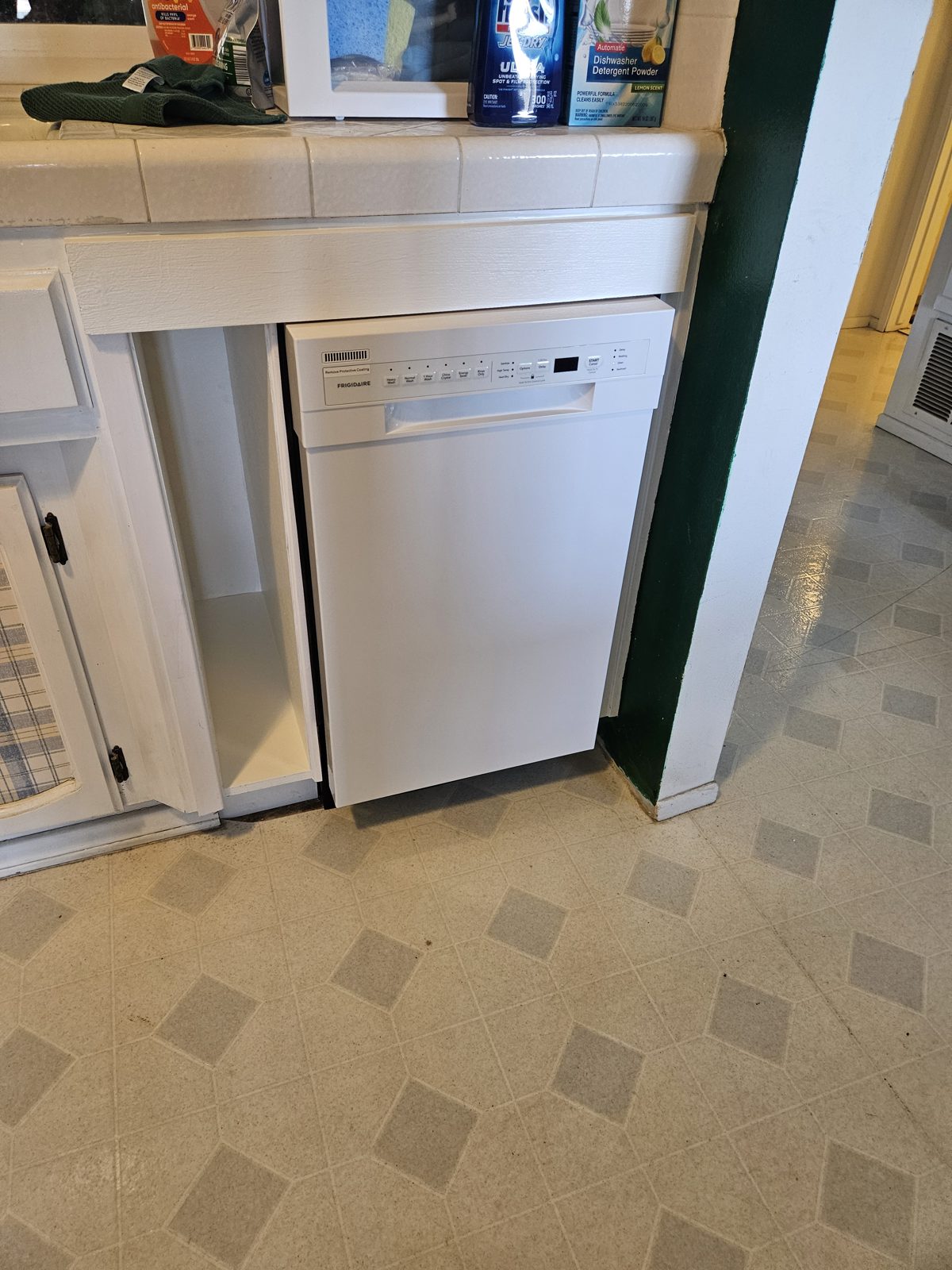 New dishwasher installed with cookie sheet storage cabinet