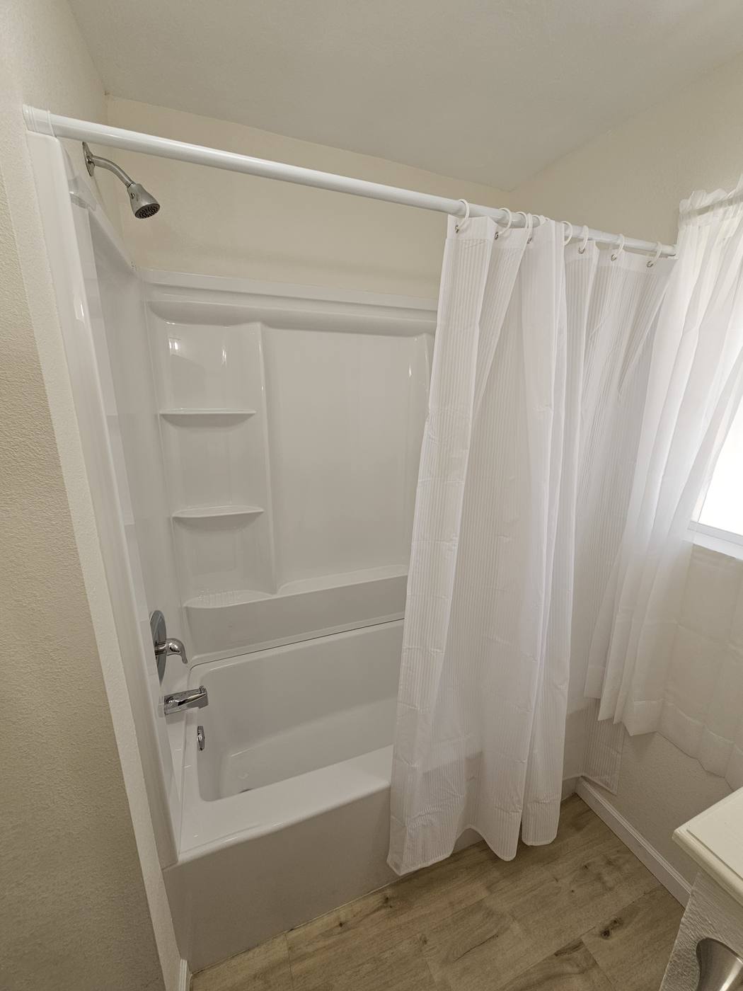 White shower insert installed in a remodeled bath