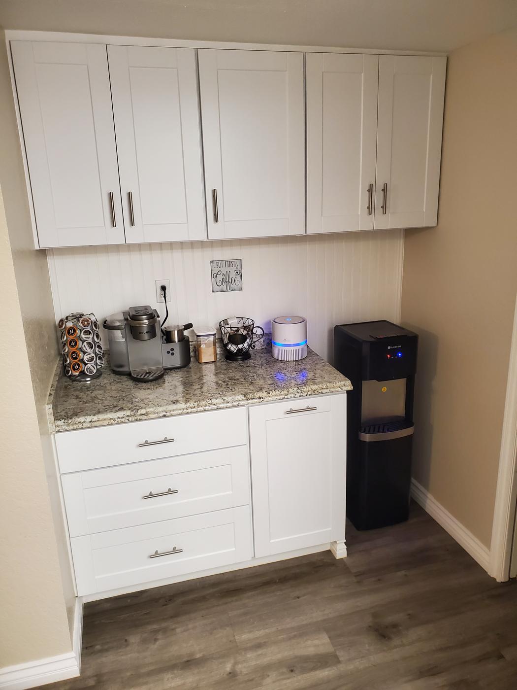 Custom built coffee bar with white shaker cabinets and granite counter
