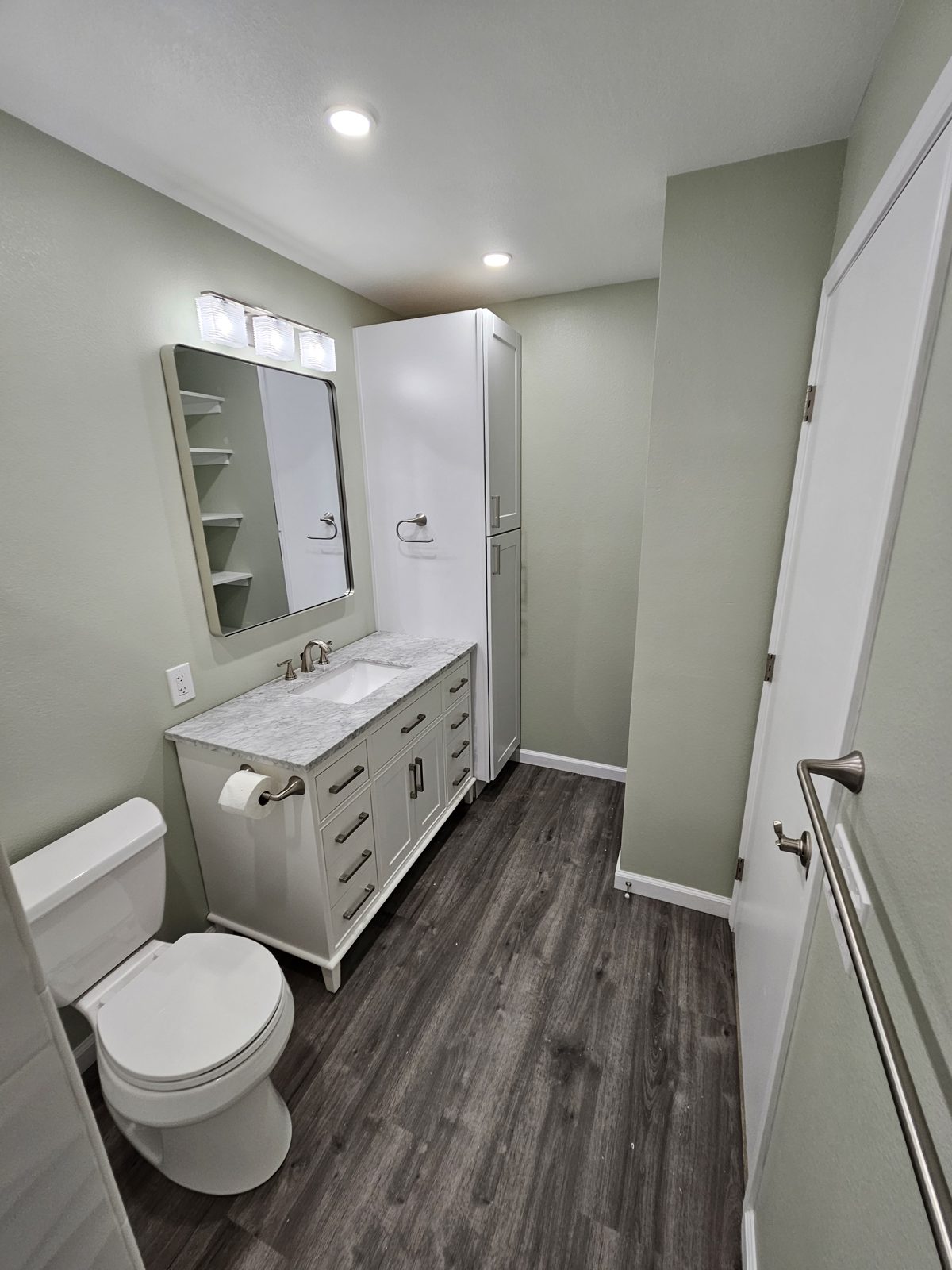 Remodeled bathroom with tile floor and new vanity